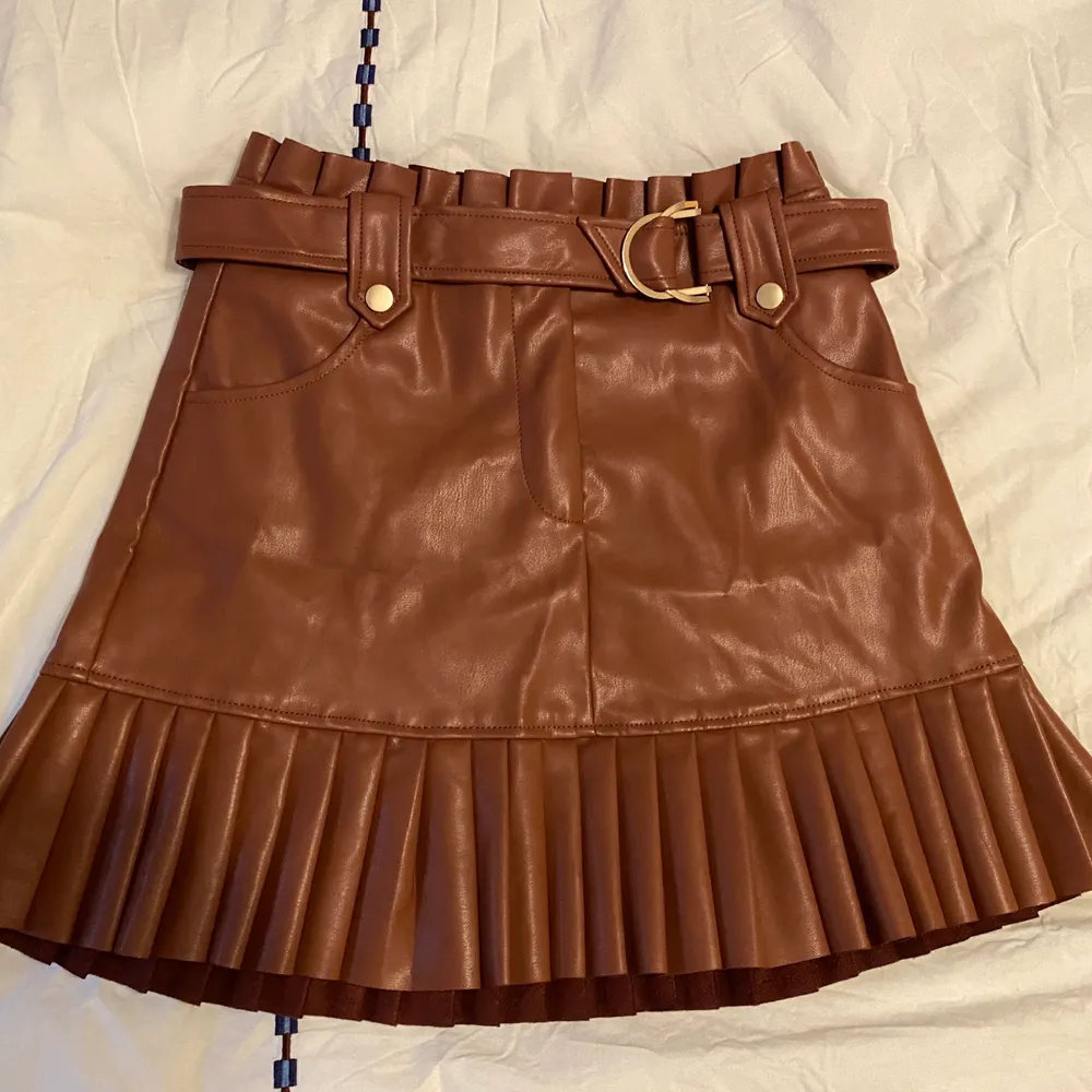 Short skirt with front pockets. Back pleat detail. Self belt with metal buckle. Pleated hem. Front zip closure. Been used a few times but still in great shape! Contact for more pictures! Buda från: 250kr. . Kjolar.