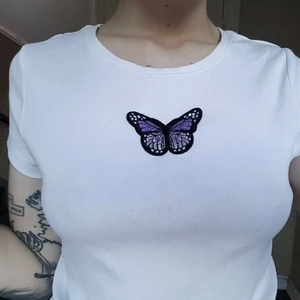 Y2K tisdag med fjäril! 🦋 - Sååå gullig Y2K dröm till tisha!!! 🦋 Tishan är helt vit och ribbad med en lila fjärilspatch på bysten 😭 Storlek XL! Passar ca M-XL. 80kr