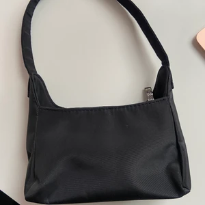 Svart nylonväska - En svart baquetteväska i nylon som jag köpte här på Plick! Passar till allt💗