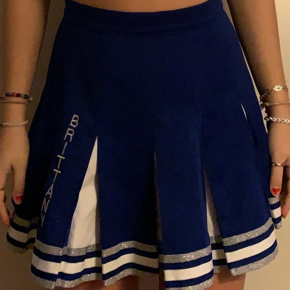 Mörkblå cheerleading kjol med texten “Brittany” 💙💙 storlek är amerikans 9 men uppskattas vara ca 36/38. Kjolar.
