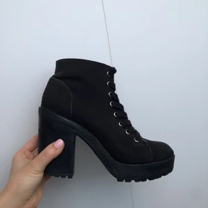 Boots - Ett par högklackade boots med knytning och grepp