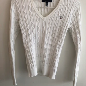 Kabelstickad GANT-tröja - Vit, kabelstickad GANT-tröja. Något missfärgad under armarna men ej märkvärdigt på utsidan. Nypris 1299 kr.