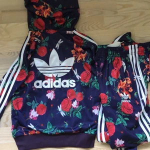 Blommigt Adidas Set - Super snygg fejk Adidas set❤️ Storleken är M men skulle säga att den mer är s/m då det går att anpassa byxorna i midjan🌺 Setet har några mindre skador men det är bara att kontakta om du har frågor eller vill se flera bilder🥰