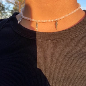 Pärlhalsband - Gulligt pärlhalsband med rosa och vita pärlor och fjäder berlocker!