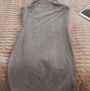 Klänning från Ginatricot - Grå klänning från Ginatricot med chokerliknande hals. 