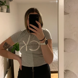 Tshirt från Calvin Klein i M - Snygg och stretchig tshirt från Calvin Klein i storlek M köpt i en av deras butiker i Italien! Den är i längre modell (uppvikt på bilden) och dessutom i skönt lite tjockare tyg
