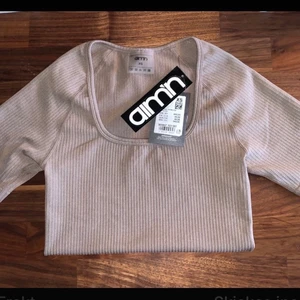 Aimn seamless shirt SX - Fin tshirt från seamless kollektionen i färgen espresso. Storlek XS, helt ny med prislappar kvar, nypris 449. Färgen ser lite olika ut beroende på ljus, bilden där tröjan är på är tagen i mörkare utrymme och den andra bilden är tagen i dagsljus.