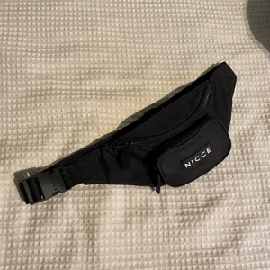 Svart Magväska - Svart magväska. Köptes på asos för nått år sedan men är knappt använd. Justerbar så den passar våder runt magen eller kroppen