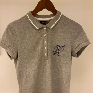 Tommy Hilfiger pikétröja  - En grå Tommy Hilfiger pikétröja med insytt märke. 