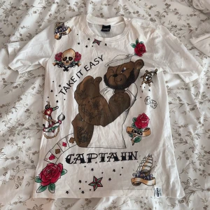 T-shirt  - Högsta bud 80+frakt!! En edhardy-liknande T-shirt köpt second hand💖 Mycket bra skick!❤️ Ascoola döskallar och rosor på, frakt tillkommer på 48kr