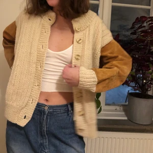 Stickad mockajacka - En stickad vit jacka med mockaärmar med fina stor knappar i mitten! Ascool modell sitter jättebra på! Modellen är s-m som referens, hör av er vid intresse🦊