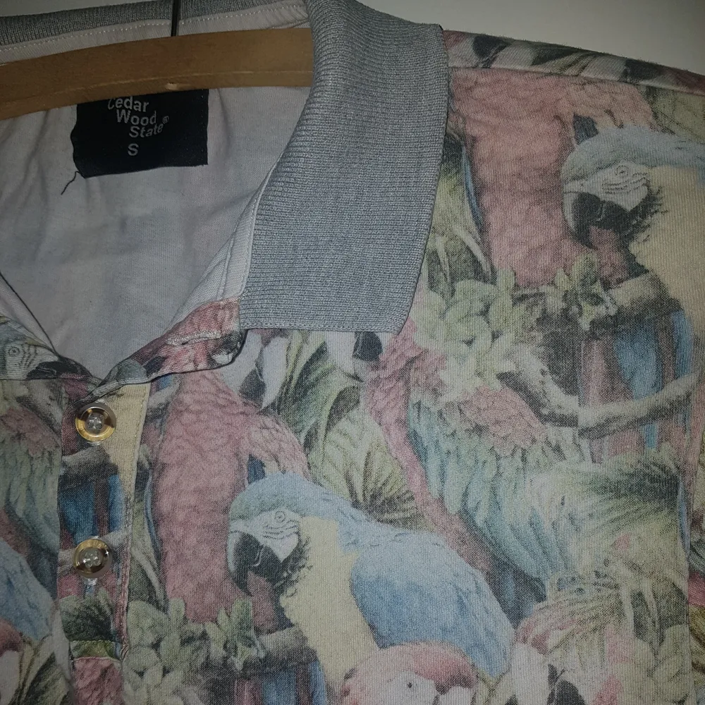 Piké tröja från Cedar wood state med pastell papegojor! Herrtröja men kan likaväl användas av kvinnor. Jag gillar den men får inte användning av den, i bra skick!. T-shirts.