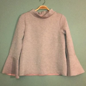 Figursydd tröja med utsvängda armar - Rosa/grå tröja stl. XS, figursydd med slits bak på armarna. Som ny! Köpare betalar frakt!