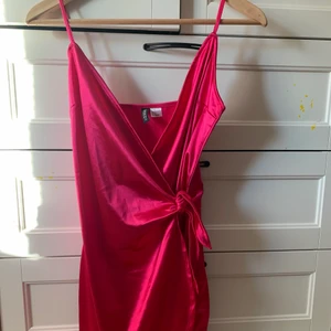 Rosa klänning  - Rosa klänning i satin med knytning vid midjan. 