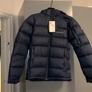 Peak Performance strl 170/S - Helt ny navy Peak Performance frost down jacka med prislapp kavar! Ny pris 2500kr säljer här för 2000 kr.