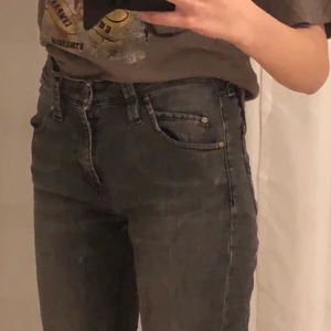 Lee-jeans med mörkgrå wash - Lågmidjade långa tajta jeans med snygg design på bakfickorna