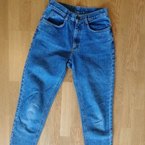 Vintage jeans från Lee - Köpt på second hand men knappt använda. Semi hög midja. Rak passform. Väldigt bekväma. Storlekslapp sitter ej kvar i plagget men mätt ut midja: 70cm. Längd: 96cm. Frakt tillkommer