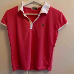 Polo lacoste - Rosa polo från Lacoste. Helt okej skick, lite nopprig. Frakt tillkommer💗