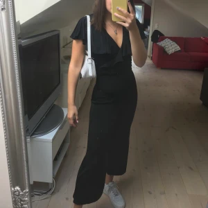 Svart jumpsuit med volang - Superskön och snygg jumpsuit från Bershka med öppning i ryggen. Bara använd 1 gång, frakt tillkommer