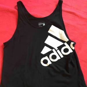  - Riktigt nice vintage linne i bomull med lite längre passform och en slits nertill på ena sidan. Svart med vitt adidastryck på bröstet. Köpt på Urban outfitters i Köpenhamn på deras vintageavdelning. 