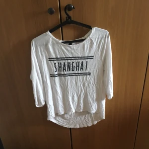  - En lagom tight mjuk tröja med texten "Sanghai" köpt från H&M
