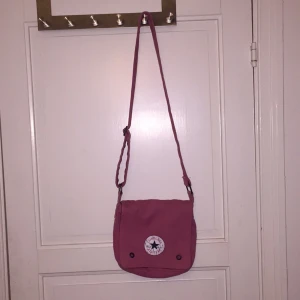  - Axelremsväska i rosa med lila nyanser ifrån converse. 