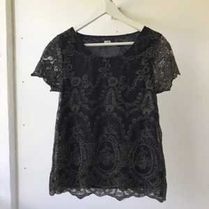  - Superfin svart topp med guldiga detaljer! Aldrig använd. Dock har lappen med storleken försvunnit. Sitter som en Small. Från BIK BOK. 
