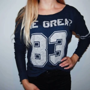  - En blå långärmad tröja i S Med text THE GREAT 83 