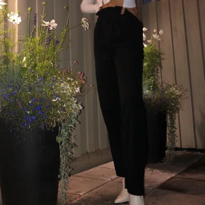 Svarta kostymbyxor  - Ett par lite fladdrigare kostymbyxor som är aningen högre i midjan! Så snygga alltid, oavsett nedklädda eller uppklädda. Har resårband i midjan så de hålls på plats utan knappar eller dylikt. Köpare står för frakt. 