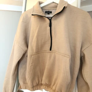 beige tröja med dragkedja - beiga tröja med dragkedja från bohoo i storlek 36, endast använd en gång så i bra skick. köparen står för frakten!!