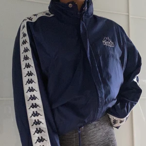 Kappa jacka  - Mörkblå kappa vindjacka med t-shirt foder. Mjuk och härlig inuti. Använd enstaka gång av mig men är köppt vintage. Men är i gott skick. Köparen står för frakt, möts på söder annars. Håll utkik i min profil för mer🥰