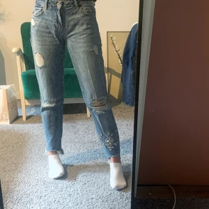 Zara jeans med pärlor storlek 34 - Jätte bekväma jeans från zara med en lite lägre midja och pärlor på ena benet passar mig med storlek 36 men sitter då lite tightare.                           Priset gäller utan frakt!
