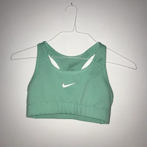 Sports bra från Nike - Nike Dri-Fit sports topp i supersnygg ljusgrön färg. Väldigt sparsamt använd och säljer endast p.g.a för liten för mig. Storlek S stretchig men sitter tight på så perfekt för att sporta i. 100kr utan frakt Möts i Sthlm eller fraktar