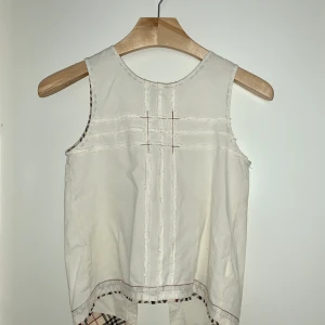 Retro Burberry topp med öppen rygg - Retro Burberry topp med öppen rygg i storlek 12 år, passar dock storlek xs-s i vanlig damstorlek. Passformen är som på bild 3 (dock inte min bild men den visar hur linnet sitter på). 