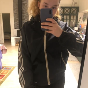 Adidas jacka - Retro, mörkblå, tunnare jacka från Adidas som jag köpt secondhand men använder allt för sällan!!  Den är rak där fram, men har resår där bak  🌟storlek står inte men passar mig som är M, 170 cm lång  🌟 se bild för material 🌟inget särskilt att anmärka på i skicket, fint begagnat skick 🌟150