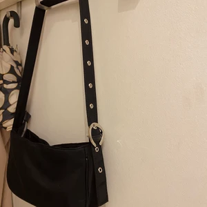 Väska  - Liten axelremsväska, justerbar längd! Som nyskick då den knappt är använd. Köpare står för frakt som tillkommer på 60kr! 
