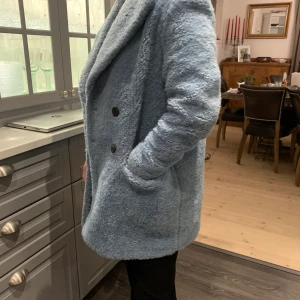 Ljusblå kappa - En ljusblå kappa inifrån zara 