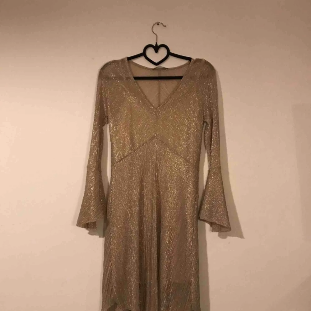 Somrig guld-glittrig klänning med underklänning Skick: Oanvänd, köpt second hand. Fraktkostnad tillkommer. Klänningar.