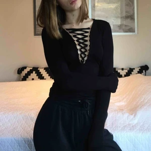  - Svart långärmad topp med snördetalj. Säljer då den inte kommer till användning för mig. Endast använd en gång tidigare. Frakten ingår!