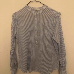  - Söt randig blus i materialet som en skjorta. Vit och blå randig. Passar även om man har storlek 36. 