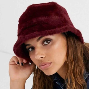  - Fet buckethat i vinröd fuskpäls från Asos. Endast testad så är 10/10. Omkrets: 57cm Originalpris var 195kr plus frakt (bilder från asos)
