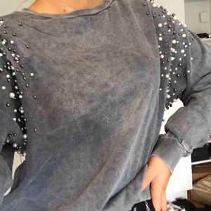  - En grå tröja med pärlor på armarna. Inte använt så mycket,är i bra skick frakt 60kr