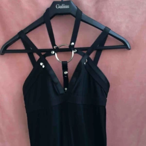  - Byxdress med vida ben och harness upptill. Dragkedja i ryggen  
