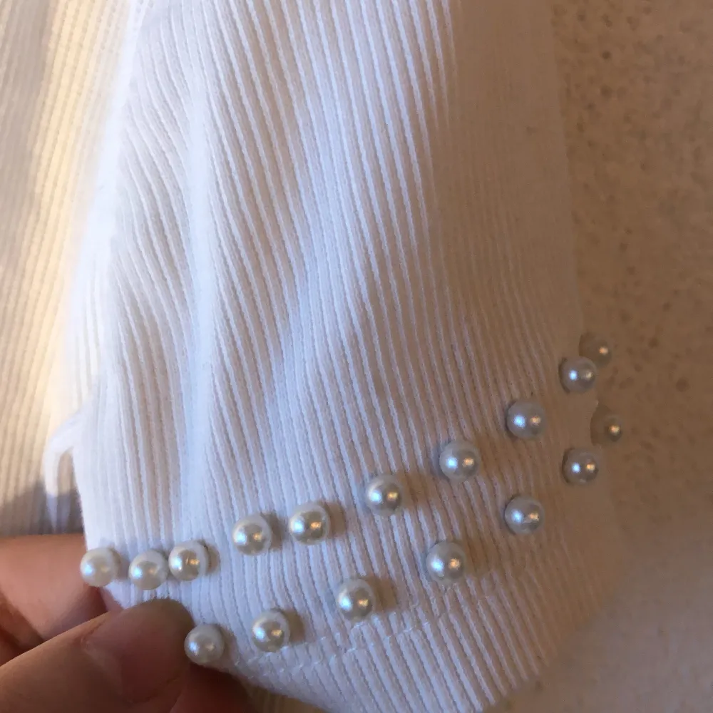 en ribbad cropped tröja med pärlor i ärmen, sitter lite löst vid nederdelen:D. Toppar.