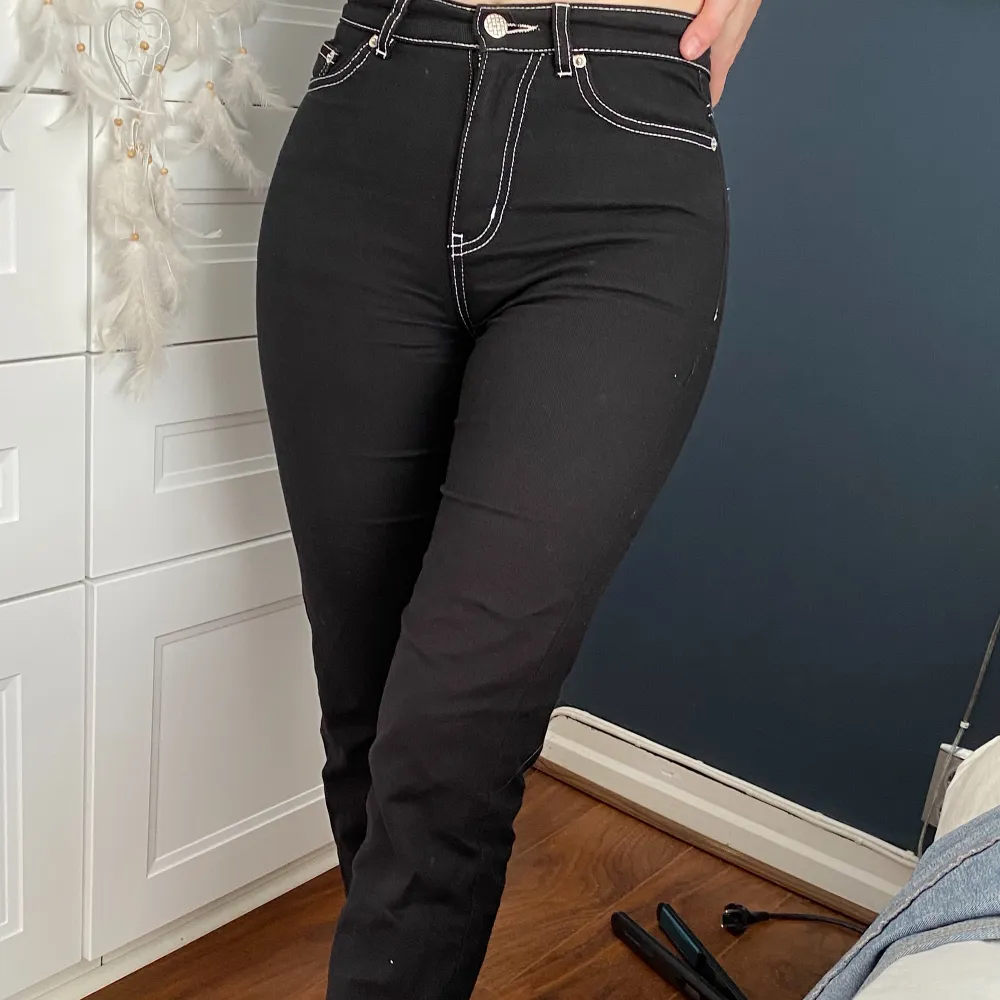 Svarta snygga jeans från Junkyard, med vita sömmar. Normal höjd i midjan. Jag är 162 cm. Storlek 34.. Jeans & Byxor.