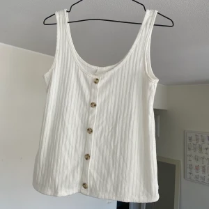 Linne med knappdetaljer - Vitt linne i nyskick! Köpt förra sommarsäsongen 🕊 obs! knappar är endast detalj, går ej att öppna! Hämtas i Sundbyberg, annars står köparen för frakt!