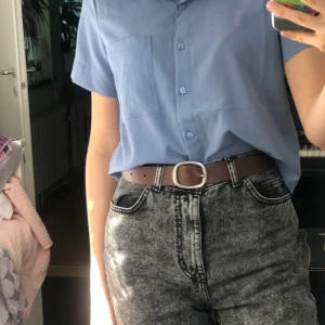 Somrig skjorta  - Somrig halv-croppad blå skjorta. Aldrig använd. Tunnt och luftigt tyg. Frakt 20kr, frakten är inkluderat i priset🥰 köparen står alltså för frakten 