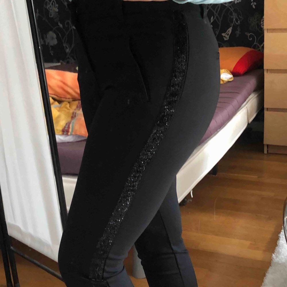 Svarta kostymbyxor med en glitterrand på sidorna från vero Moda  Säljer pga ej min stil. Köpare står för frakt. Jeans & Byxor.