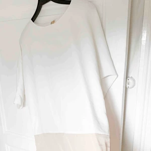  - En klänning som är vit upptill och beige nedtill. Står varken storlek eller märke men skulle uppskatta att storlek är S-M. Dock har jag använt den som oversized! Tyget är glatt.