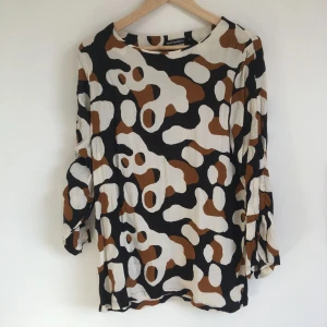 - Långärmad blus i viskos crepe från Marimekko. Dragsko i ärmarna så att man kan rynka upp dem lite om man vill. Lös passform.